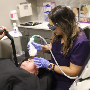 Dr. Stef performing a Moxi treatment on a Hispanic female.